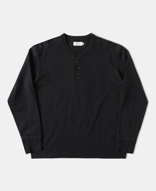 A black long-sleeve henley shirt with a three-button placket, laid flat against a light gray background.