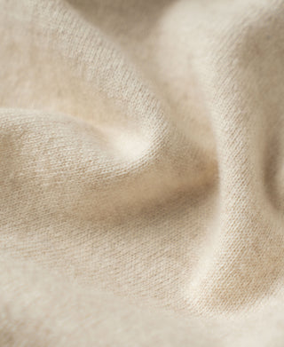 Apricot merino wool sweater fabric texture knit close-up.