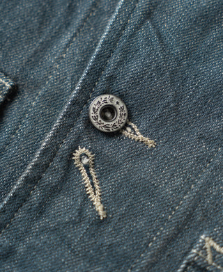 Blue denim barn jacket front placket with round metal button and bar tacks