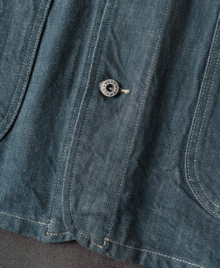 Blue denim barn jacket lower front placket with round metal snap and yoke stitching