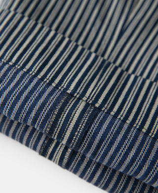 Striped trousers fabric close-up, blue and off-white pinstripes with stitched hem.
