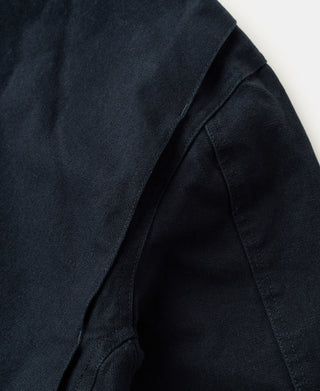 Navy cotton canvas jacket with angled pocket opening and interior fabric panel