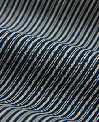 Striped trousers fabric close-up, wavy blue and off-white pinstripe texture.