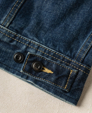 Indigo denim jacket hem with two black buttons and bar-tack reinforced stitching
