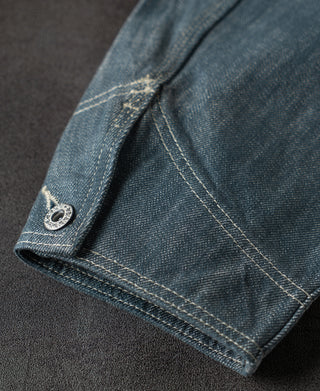 Blue denim barn jacket sleeve cuff with metal snap detail and contrast stitching