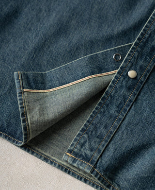Denim shirt pocket with metal snap and light interior lining, folded