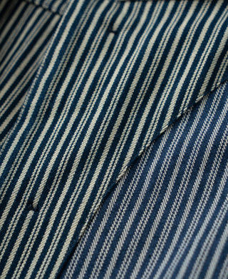 Close-up of blue-and-white striped fabric on a buttoned jacket