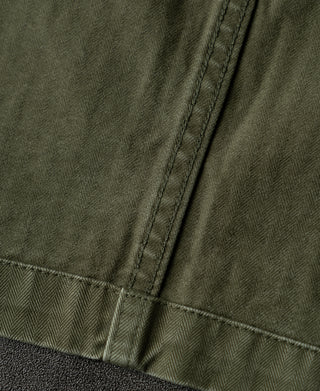 Olive blazer lower pocket area with herringbone fabric and topstitching