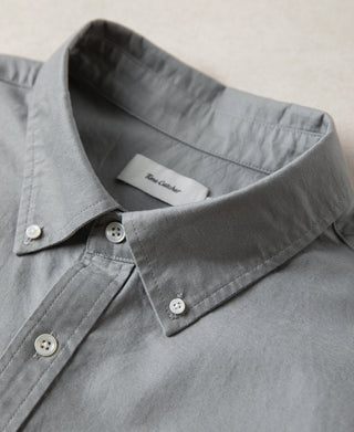 Gray button-down shirt neckline with collar points and white button placket