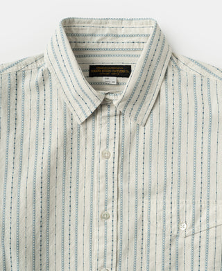 Close-up of shirt collar, button front and chest pocket with blue woven stripes