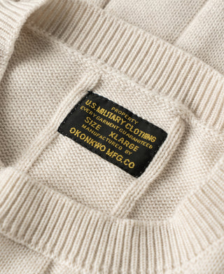 Interior brand tag on apricot cable knit sweater collar