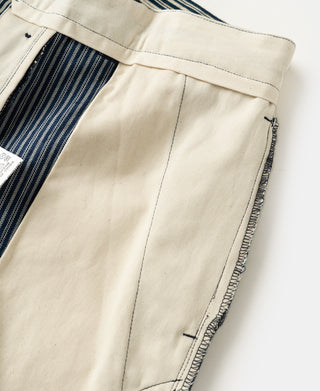 Off-white waistband and side pocket on blue-and-white striped work trousers