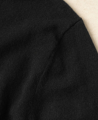 Black merino wool sweater knit fabric close-up with subtle grain