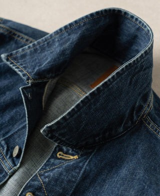Indigo denim jacket collar and inner lining, showing top button and seam stitching