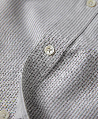 Striped button-down shirt with white button near collar, close-up