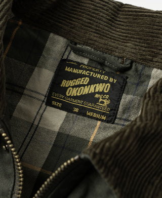 Plaid-lined label inside olive canvas field jacket showing size and branding