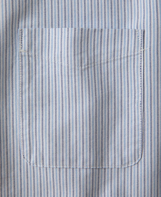 Close-up of blue-striped oxford fabric with seam and hem stitching