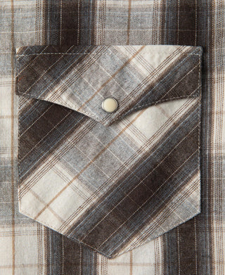 Plaid Western shirt point pocket close-up with flap and round button detail.