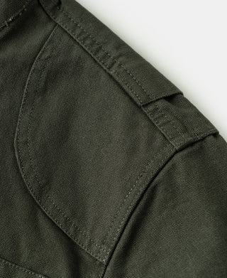 Olive jacket sleeve cuff close-up with stitched seam and reinforced panel