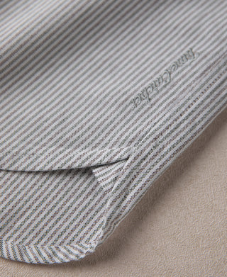 Striped shirt cuff with button and stitched edge, close-up