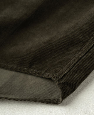 Rosin green cotton corduroy shirt hem close-up with stitched edge and fine ribs