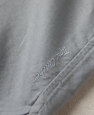 Gray oxford shirt sleeve/side embroidery with small stitched logo text