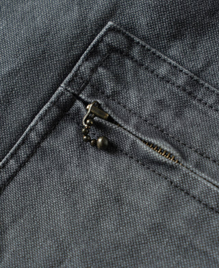 Close-up of the jacket's brass-tone zipper pull and textured canvas