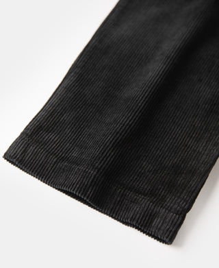 Black corduroy trouser hem with stitched cuff and ribbed texture