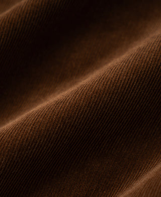 Brown corduroy fabric texture close-up, ribbed vertical pattern