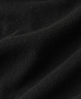 Black merino wool sweater knit fabric close-up with soft texture