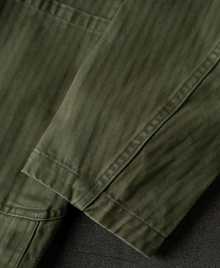 Olive herringbone blazer sleeve cuff with contrast-stitched hem