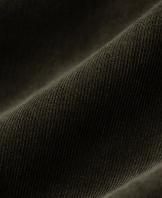 Rosin green cotton corduroy fabric texture close-up with fine vertical ridges