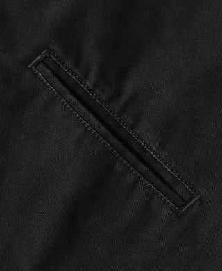 Black jacket hem edge with reinforced stitch detail and bar-tack