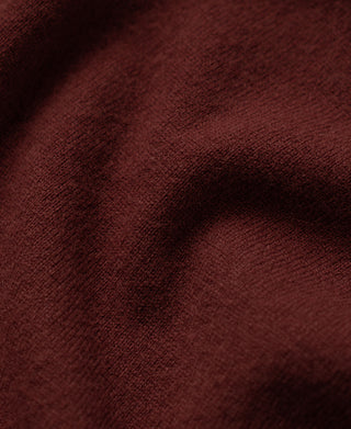 Maroon textured knit sweater fabric close-up
