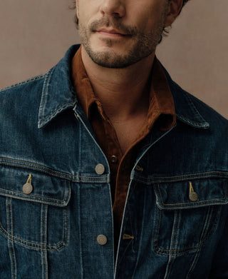 Close-up of indigo denim jacket collar, contrast seams and flap chest pocket
