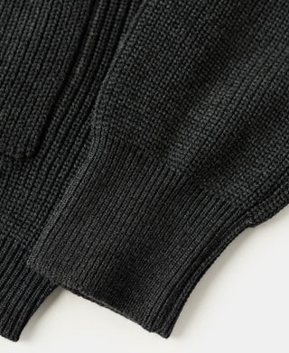 Close-up view of the rib knit texture and structured hem on a dark gray wool-blend cardigan sweater.