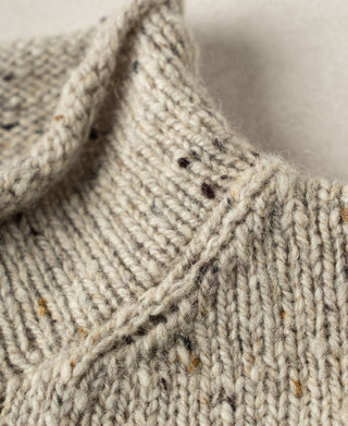 Close-up view of the shoulder construction and textured wool knit pattern on a fisherman sweater.