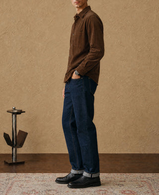 Brown corduroy button-up shirt on model, side view