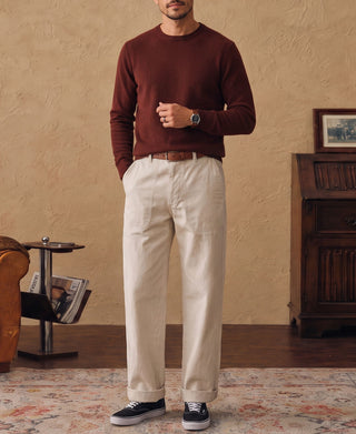 Maroon crewneck sweater on model with long sleeves and ribbed cuffs