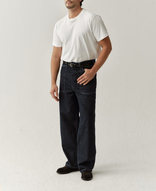 Indigo denim fatigue pants on model, straight legs, belt loops, flap side pockets