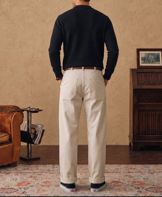 Black crewneck sweater worn from behind with long sleeves and ribbed hem