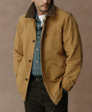 Khaki field jacket worn open, showing its dark collar and front pockets