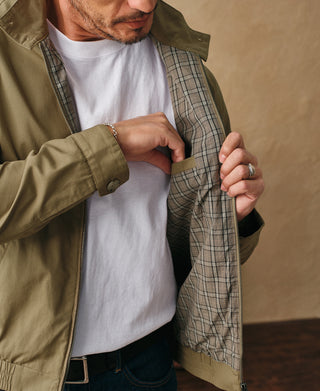 Khaki harrington jacket worn open, showing plaid lining and stand collar